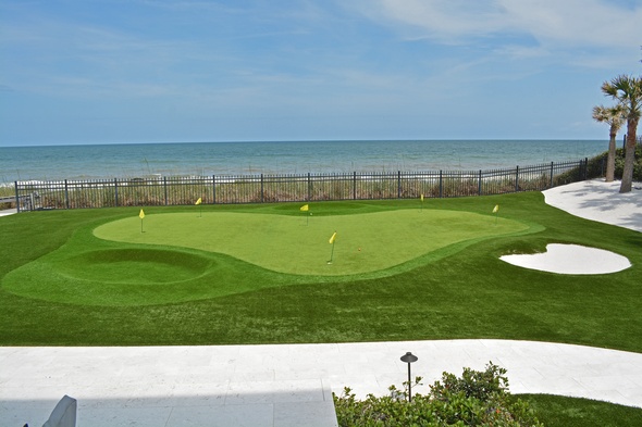 Detroit and all of Michigan Synthetic grass golf green by the sea with yellow flags and a sand bunker