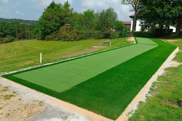 Detroit and all of Michigan Outdoor tee line consisting of one continuous green synthetic grass strip surrounded by trees